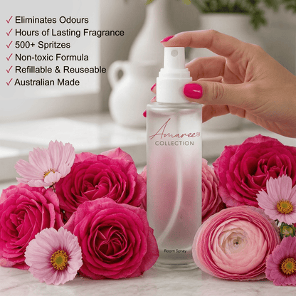 A hand with bright pink nail polish holds a frosted glass room spray bottle labeled &