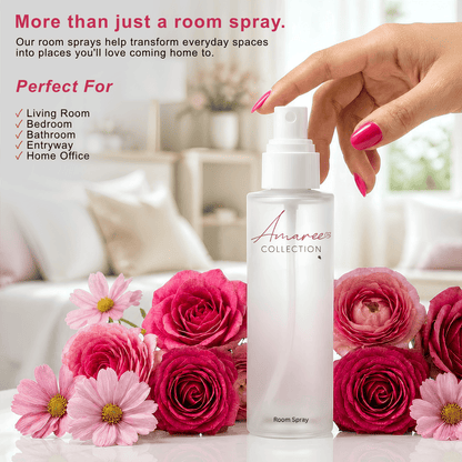 A frosted room spray bottle from the Amaree Collection, held by a hand with pink nail polish, surrounded by pink and red roses and pink daisies, with promotional text on the left.