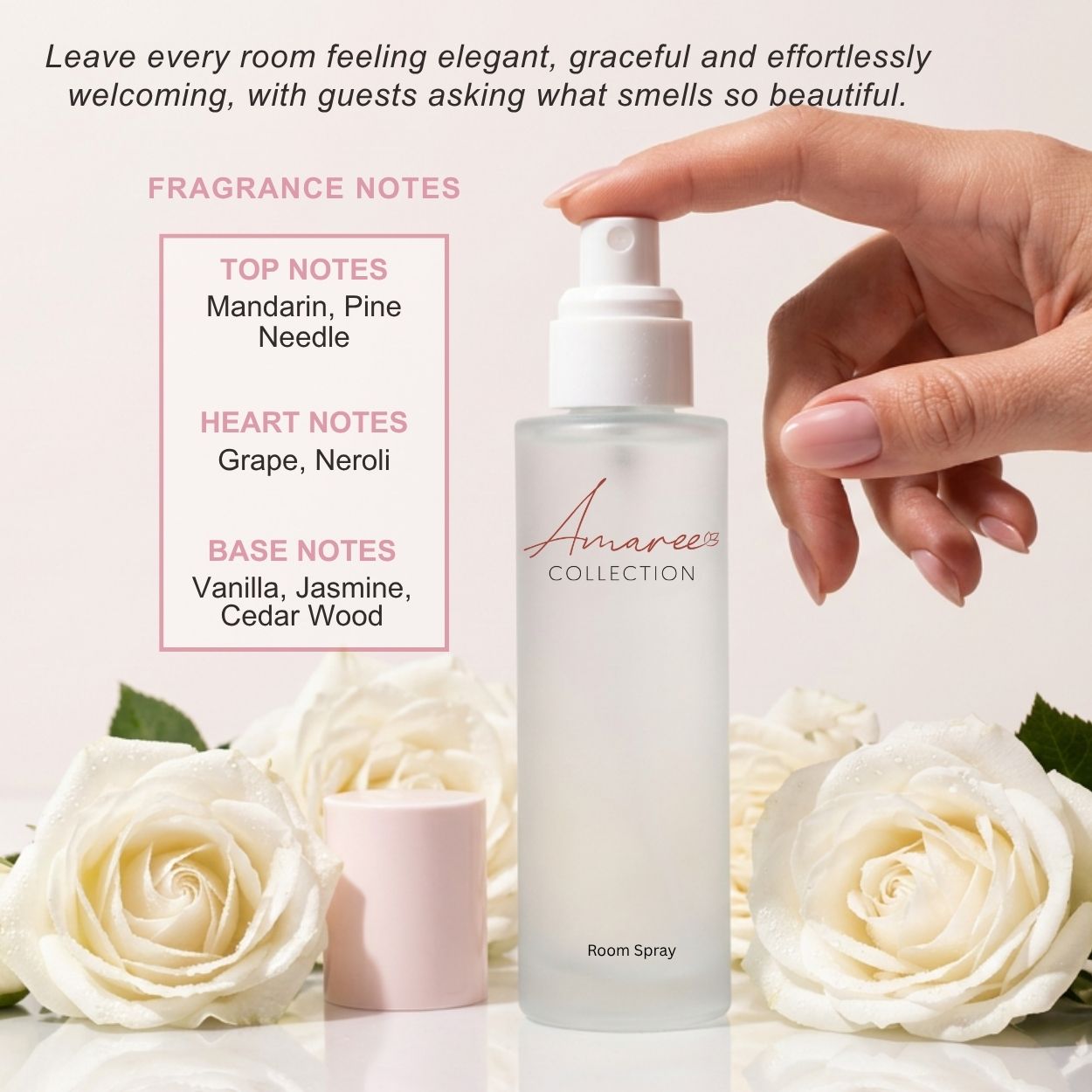A frosted glass room spray bottle with a white pump from Amaree Collection, shown with a hand pressing the sprayer. The bottle is surrounded by white roses, a small pink cap, and text detailing fragrance notes on a soft beige background.