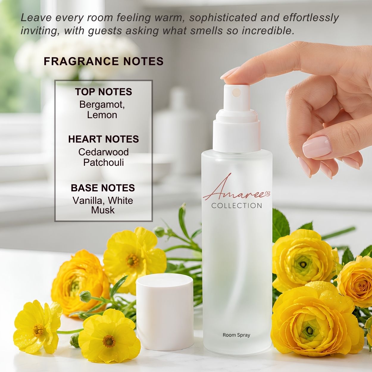 A frosted glass room spray bottle from Amaree Collection with a white cap, shown with a hand pressing the nozzle. The bottle is surrounded by yellow flowers and green leaves on a white surface, with a text box detailing fragrance notes and promotional copy at the top.