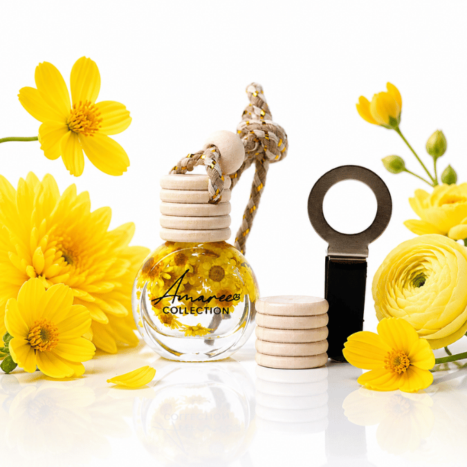 A clear glass reed diffuser bottle with a beige wooden top and rope knot, labeled &