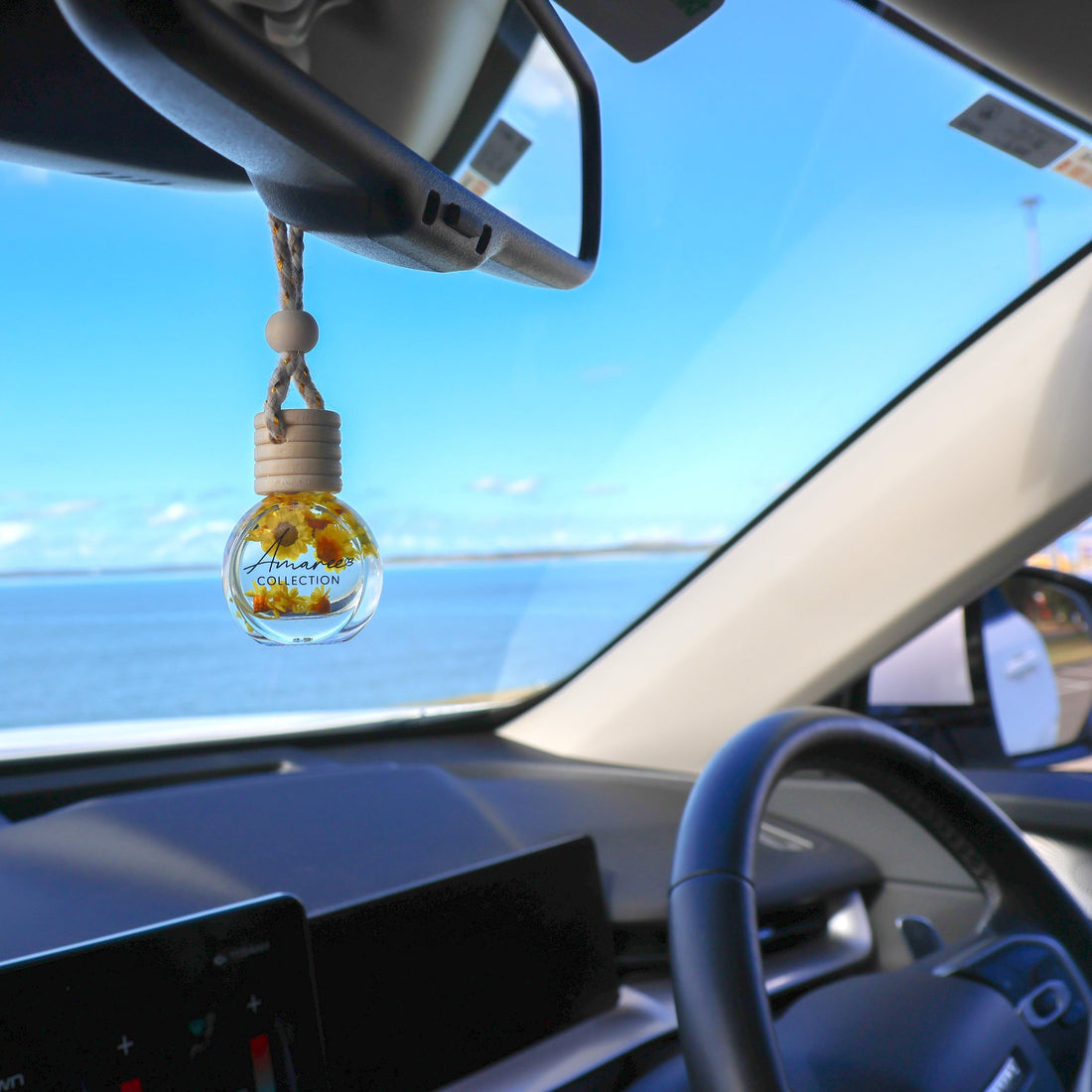 Vanilla, Patchouli &amp; Sandalwood Car Diffuser hanging from rearview mirror creating a warm, woody and sophisticated in-car atmosphere